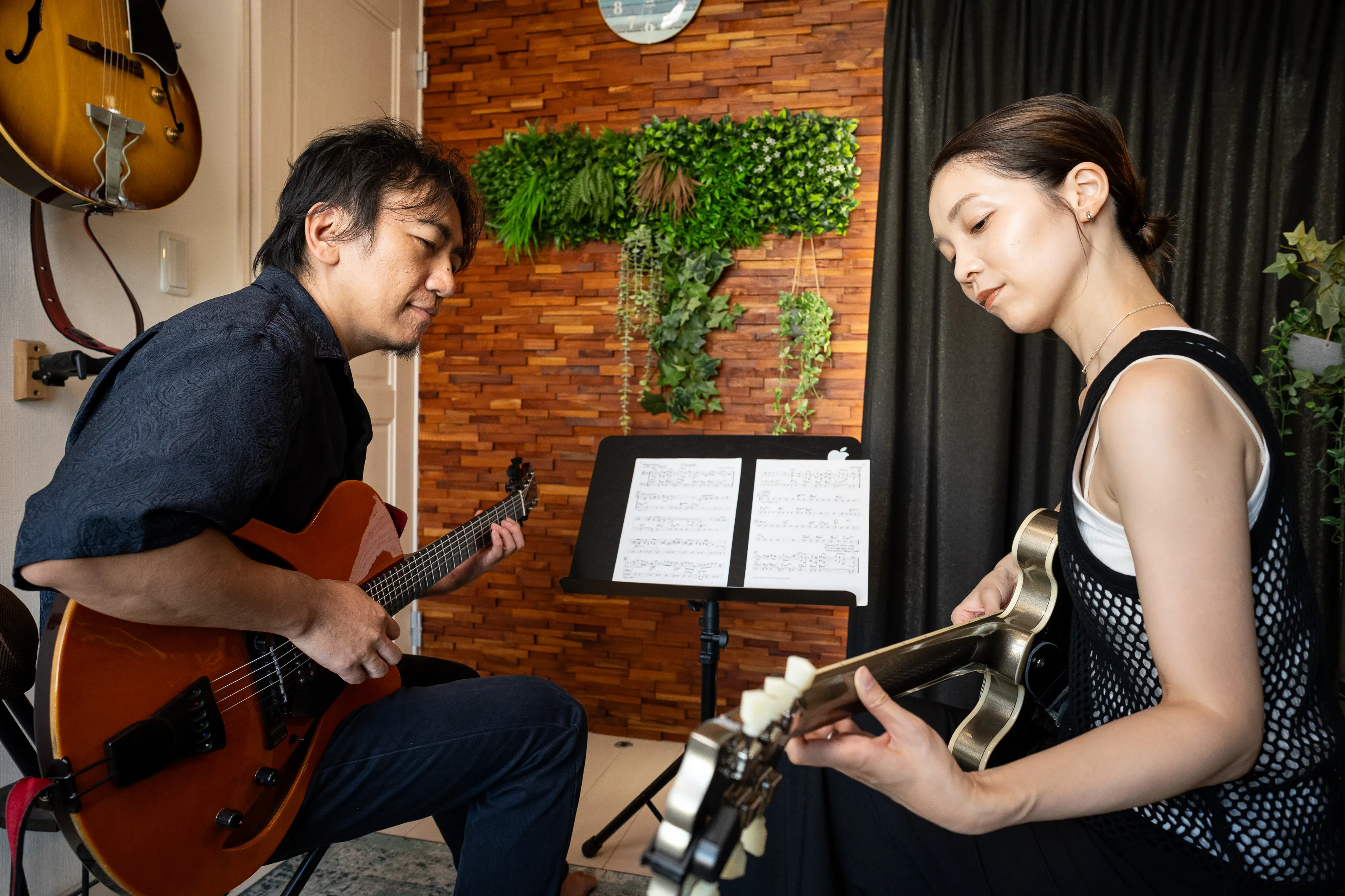 藤井進一先生と生徒が向き合ってギターを演奏する対面レッスン風景